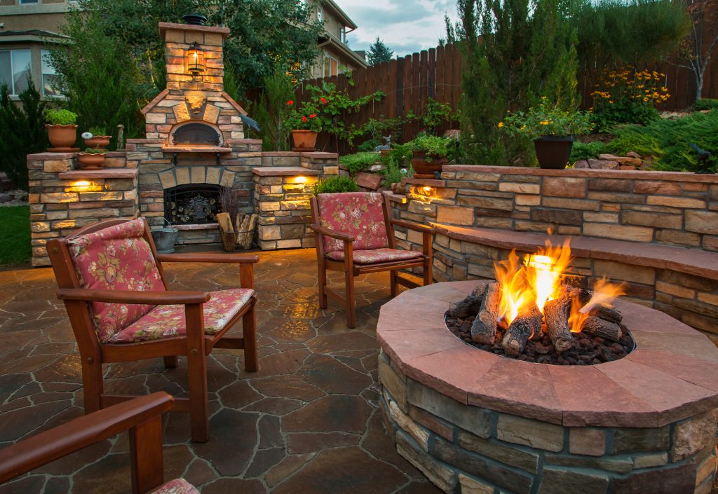 A beautiful outdoor recreational area invites to sit and stay awhile, complete with a stone fire pit and chic furniture.